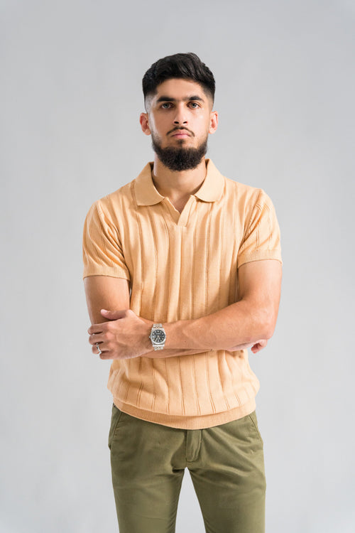 Wear Anarchy Apricot Knitted Polo for men in an arms-crossed pose with textured knit fabric and open collar