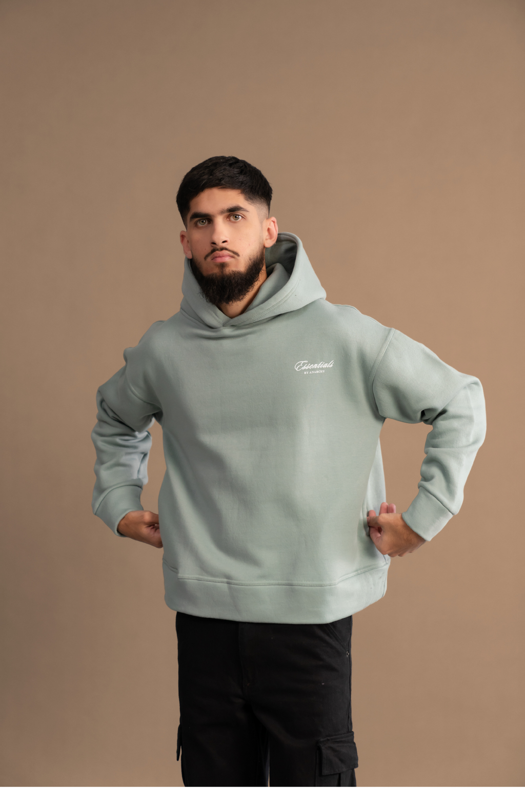 Wear Anarchy Aqua Green Essential Hoodie for men in a relaxed front pose with hood, long sleeves and embroidered chest logo
