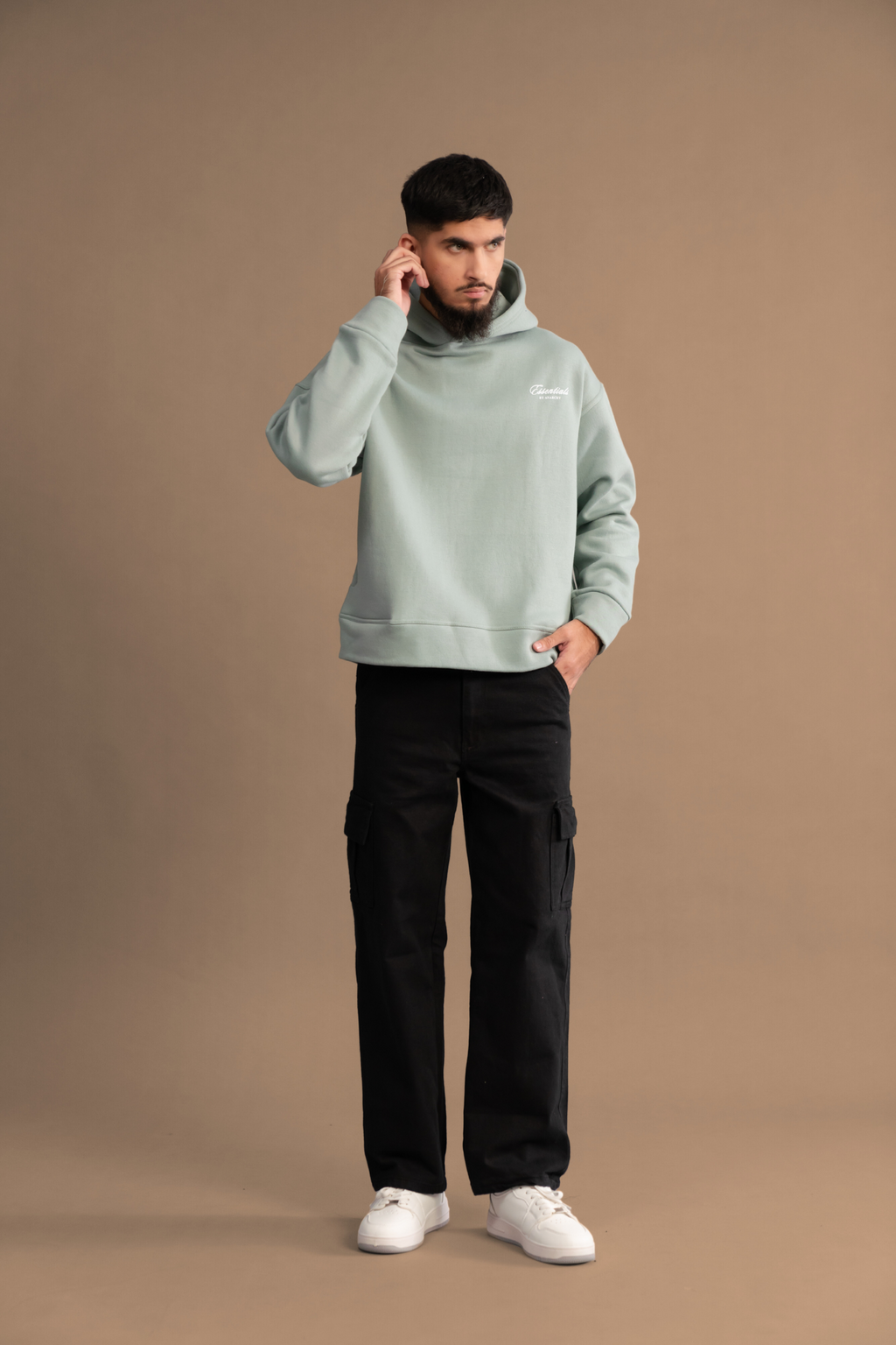 Wear Anarchy Aqua Green Essential Hoodie for men styled with black cargo trousers and white sneakers