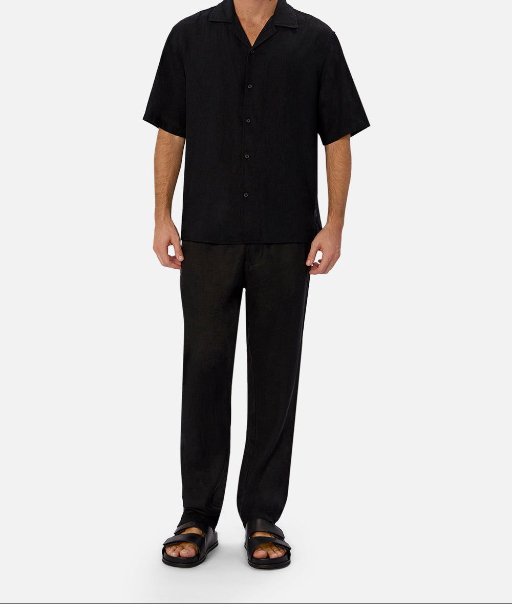 Wear Anarchy black short-sleeve button-up shirt for men styled with black trousers and sandals