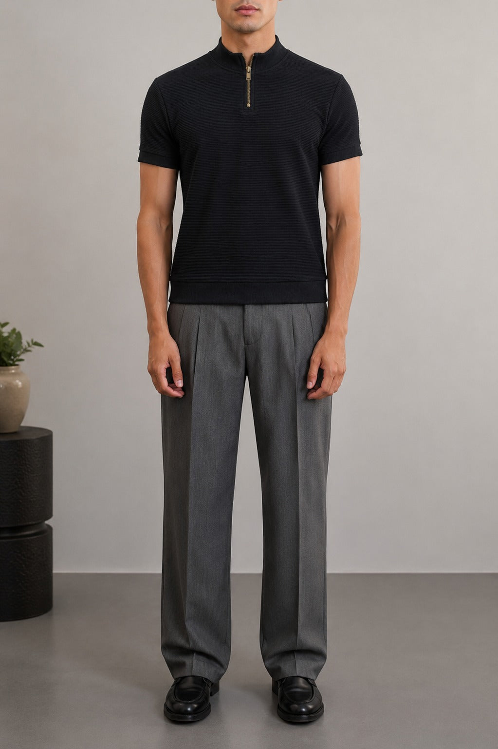 Front full-length look of Wear Anarchy black textured quarter-zip polo shirt for men styled with grey trousers and black shoes