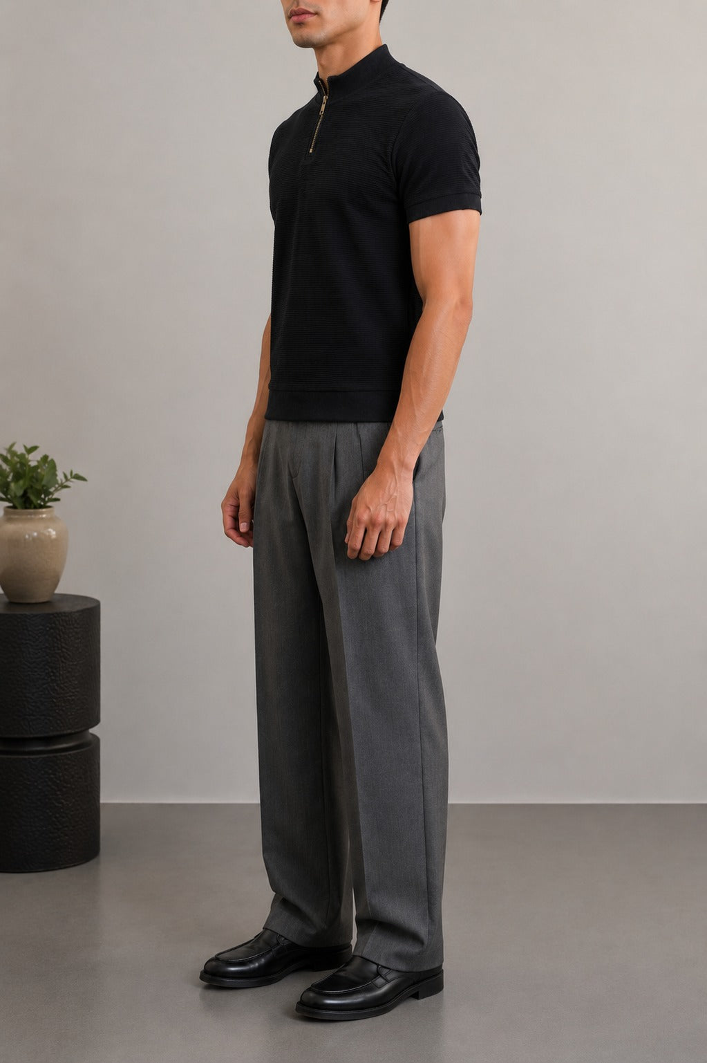 Wear Anarchy black textured quarter-zip polo shirt for men styled with grey trousers and black shoes