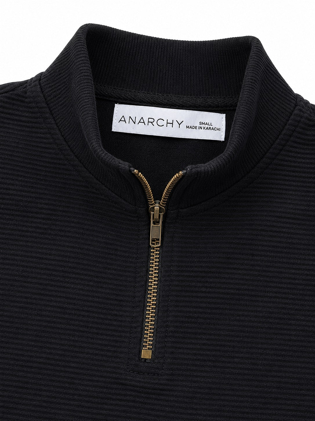 Close-up of Wear Anarchy black textured quarter-zip polo shirt showing mock neck collar and metal zipper detail