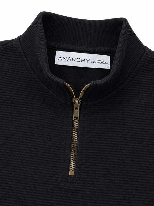 Close-up of Wear Anarchy black textured quarter-zip polo shirt showing mock neck collar and metal zipper detail
