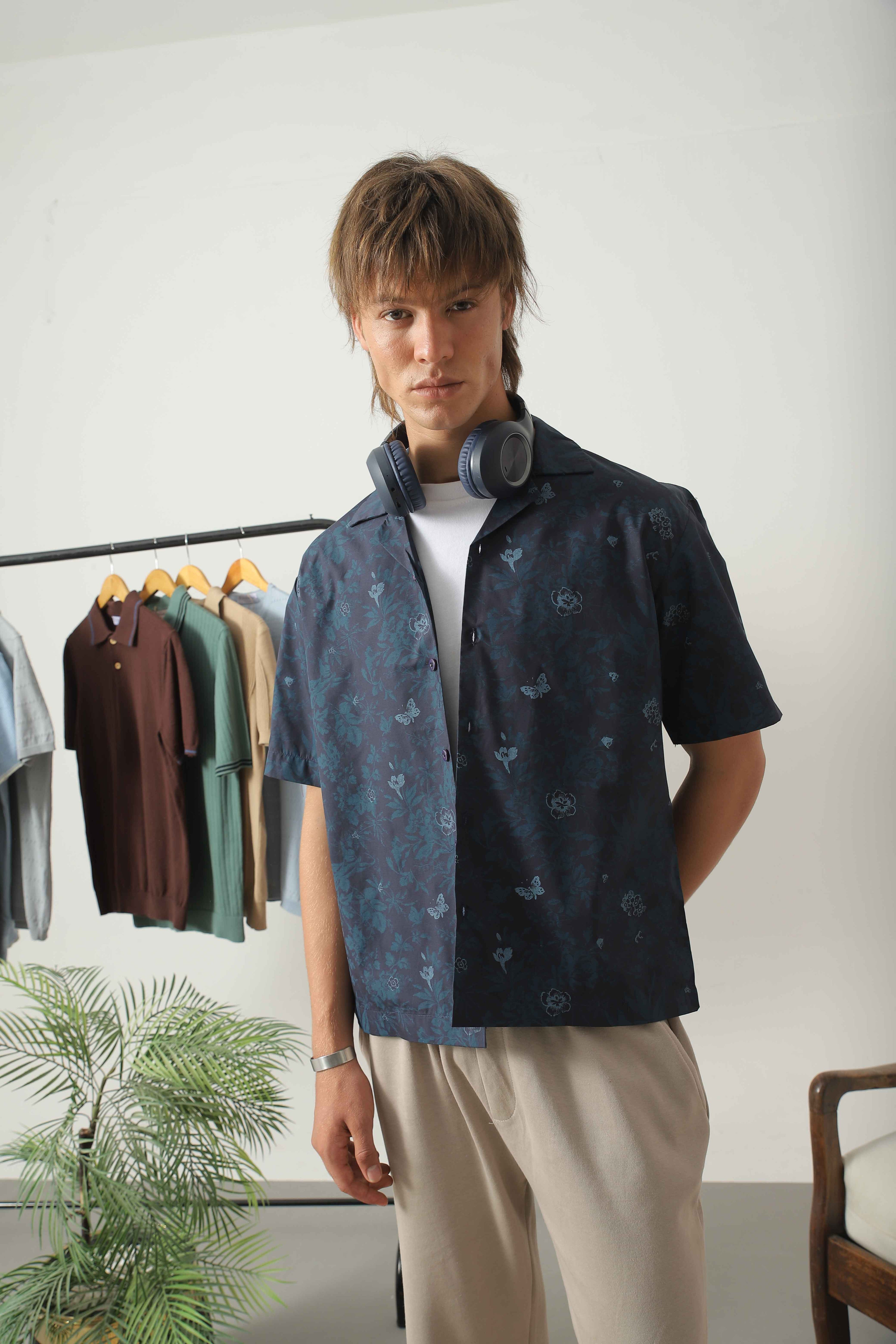 Three-quarter view of Wear Anarchy blue print resort shirt for men with short sleeves and open camp collar layered over a white t-shirt