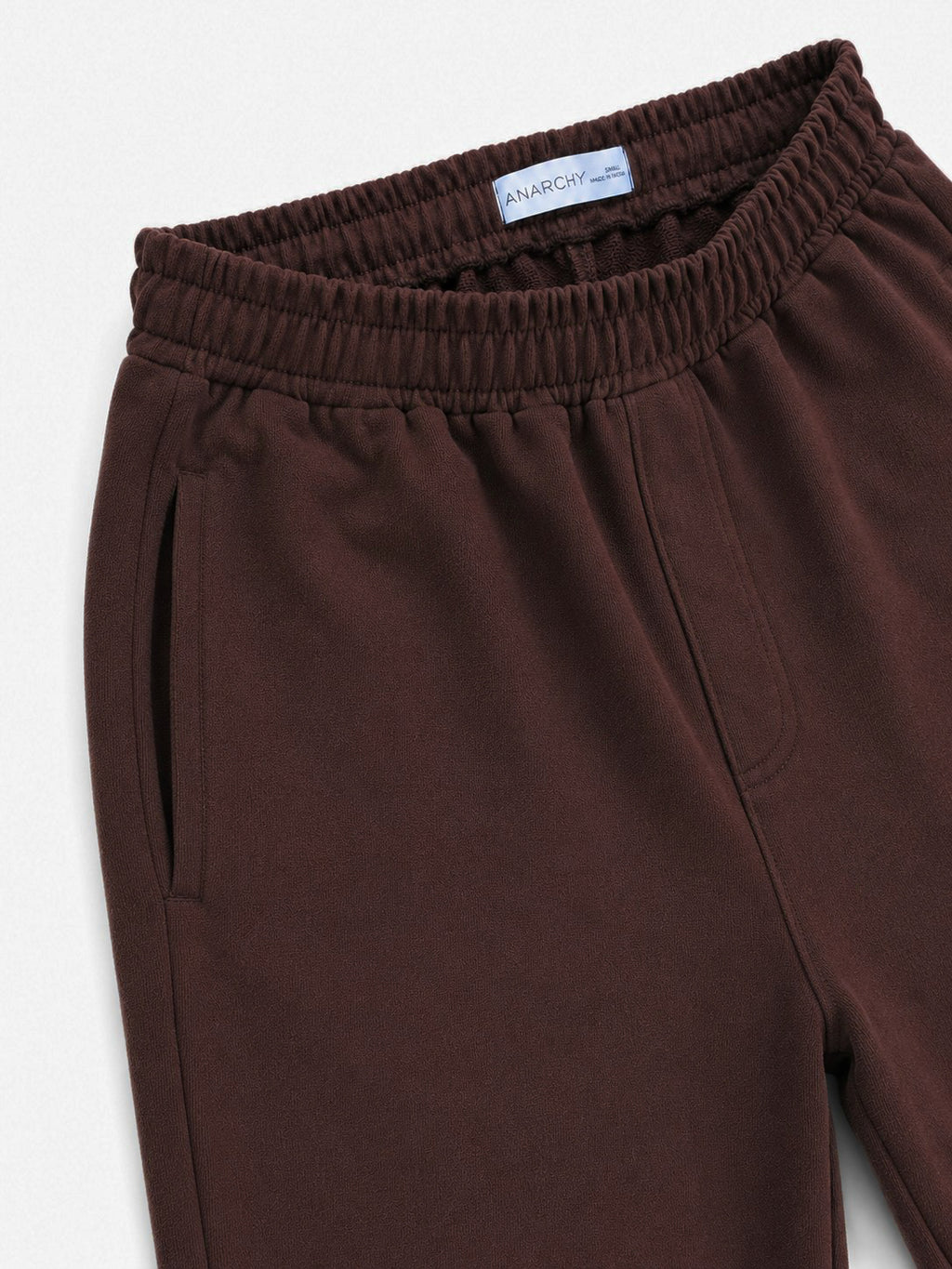 Close-up of Wear Anarchy chocolate brown terry trousers showing elastic waistband and side pocket detail