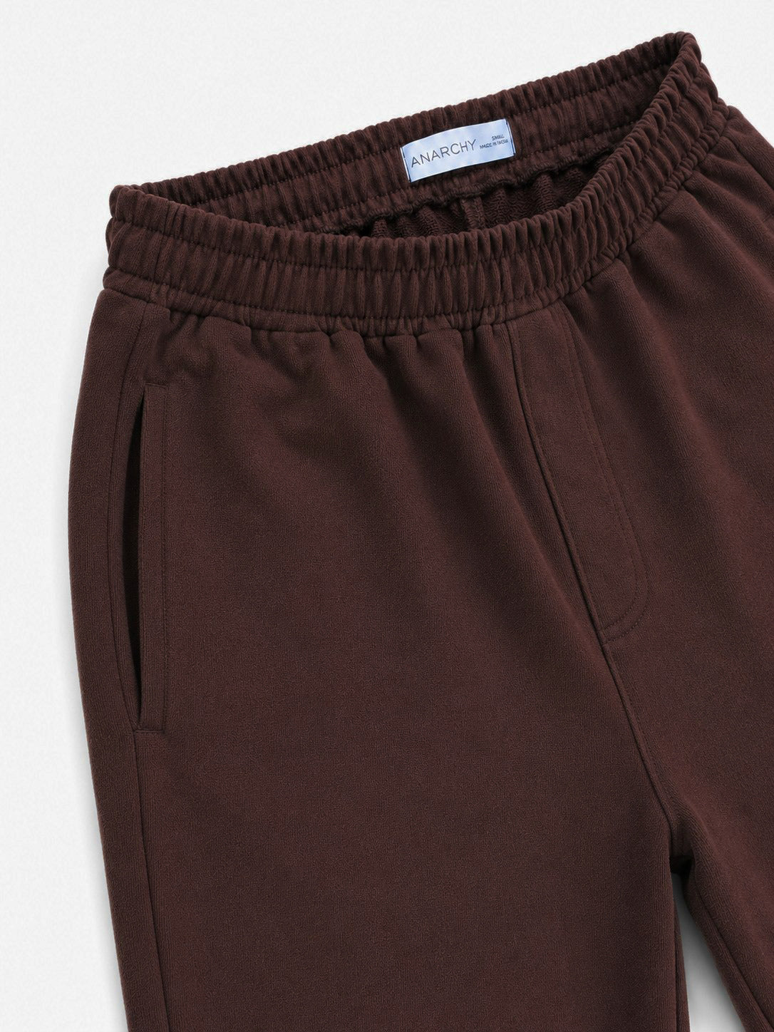 Close-up of Wear Anarchy chocolate brown terry trousers showing elastic waistband and side pocket detail