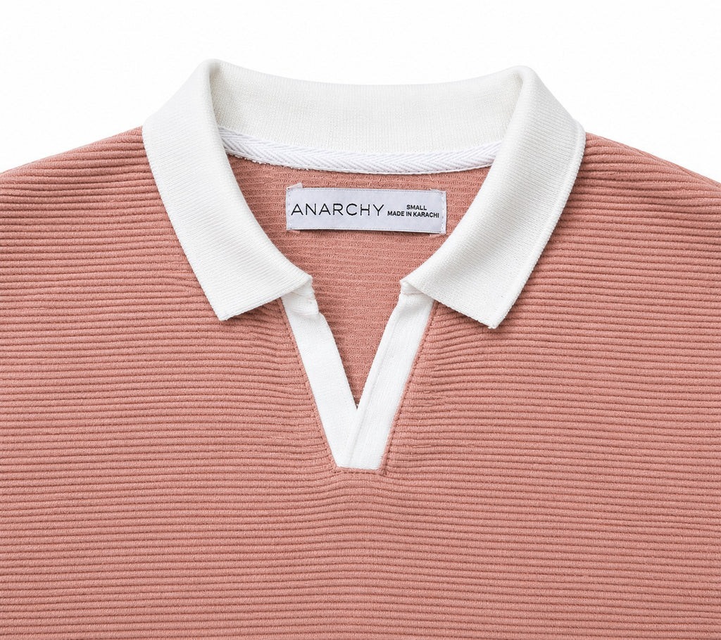 Close-up of Wear Anarchy dusty pink textured polo shirt with white contrast collar and V-neck placket
