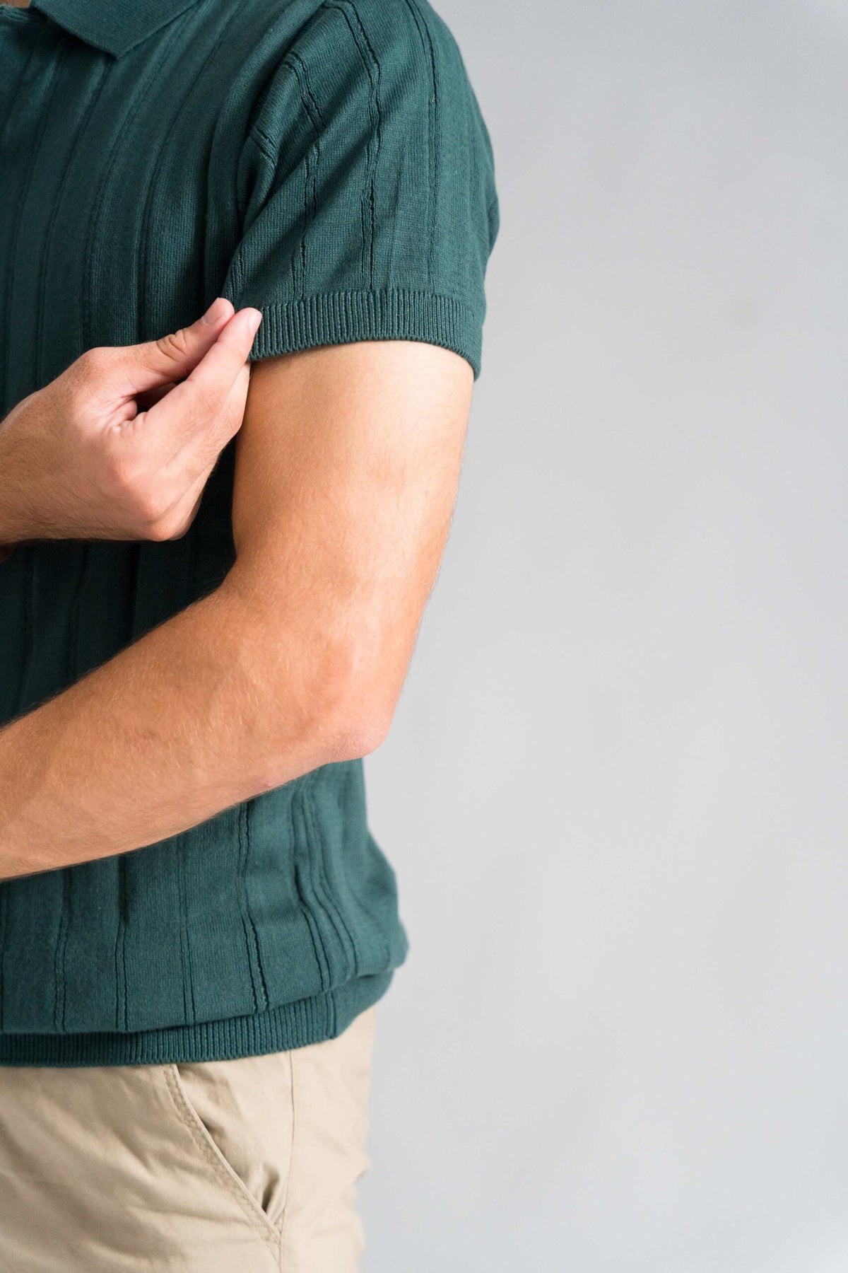 Close-up of Wear Anarchy Forest Green Knitted Polo showing ribbed sleeve cuff, textured knit and bottom hem