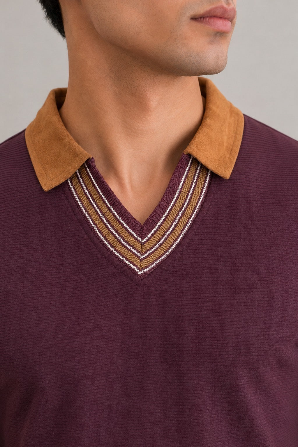 Close-up of Wear Anarchy maroon polo shirt with camel collar and striped V-neck trim