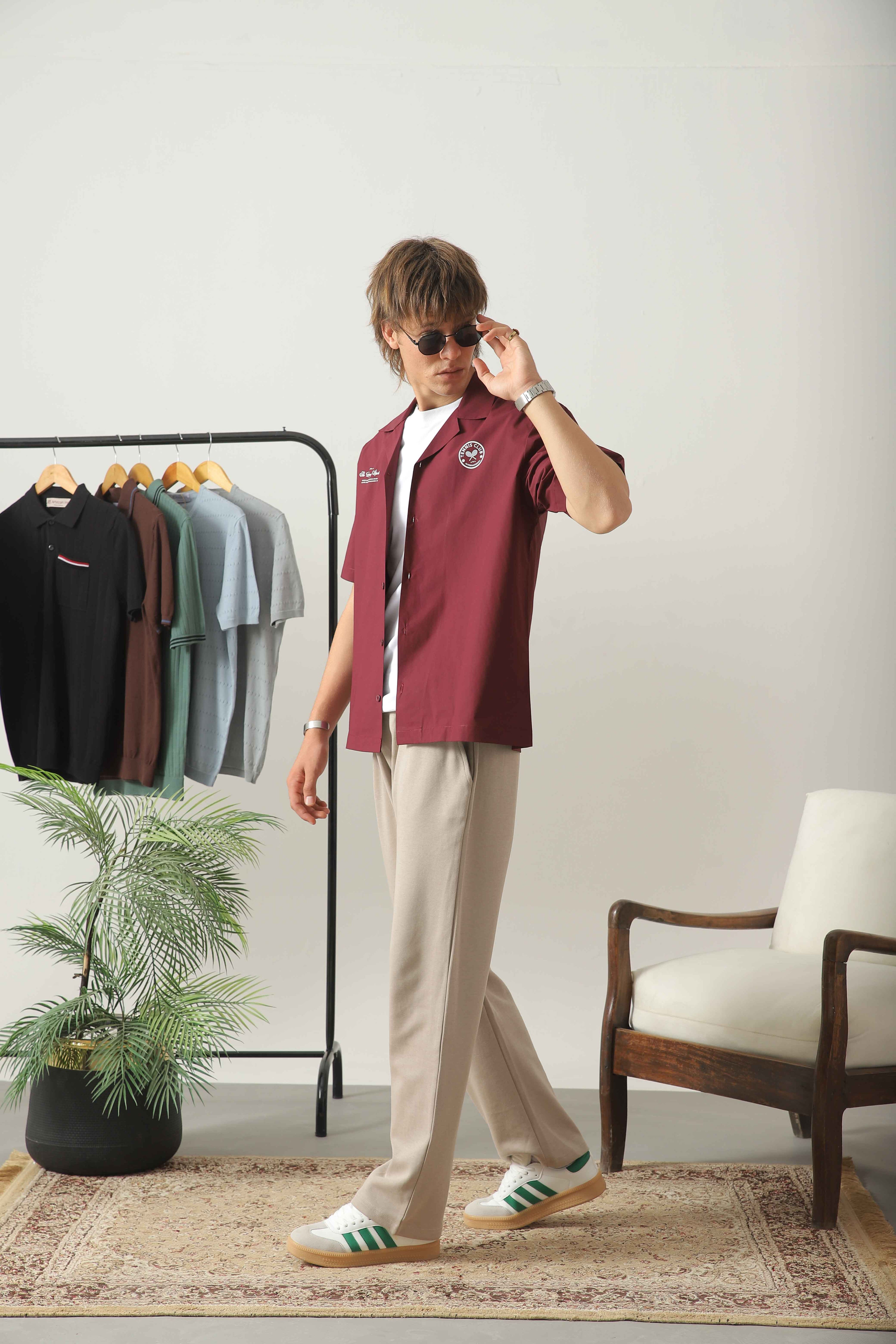 Wear Anarchy maroon golf resort shirt for men styled with beige trousers and white sneakers