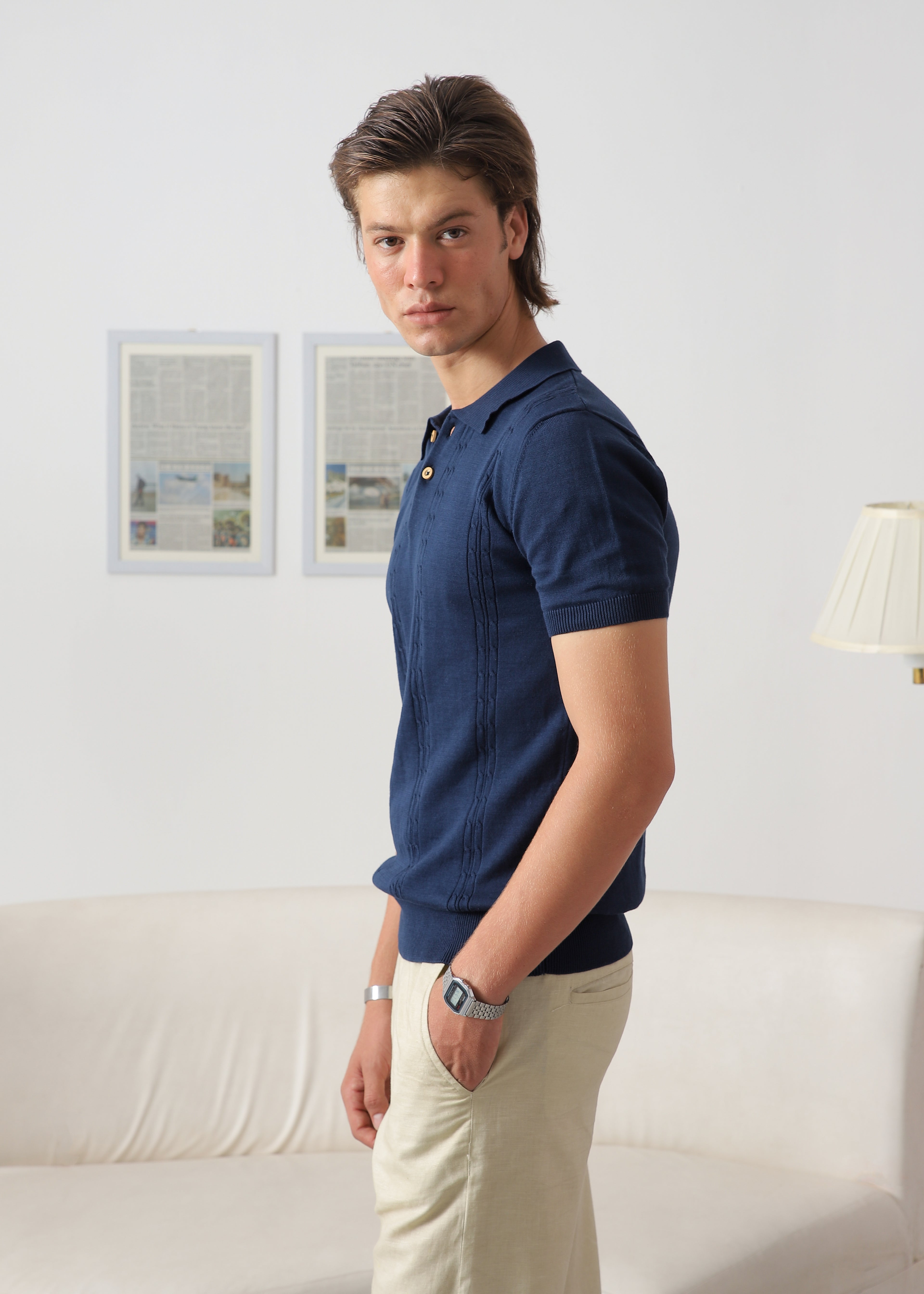 Side view of Wear Anarchy navy blue textured knit polo shirt for men styled with beige trousers