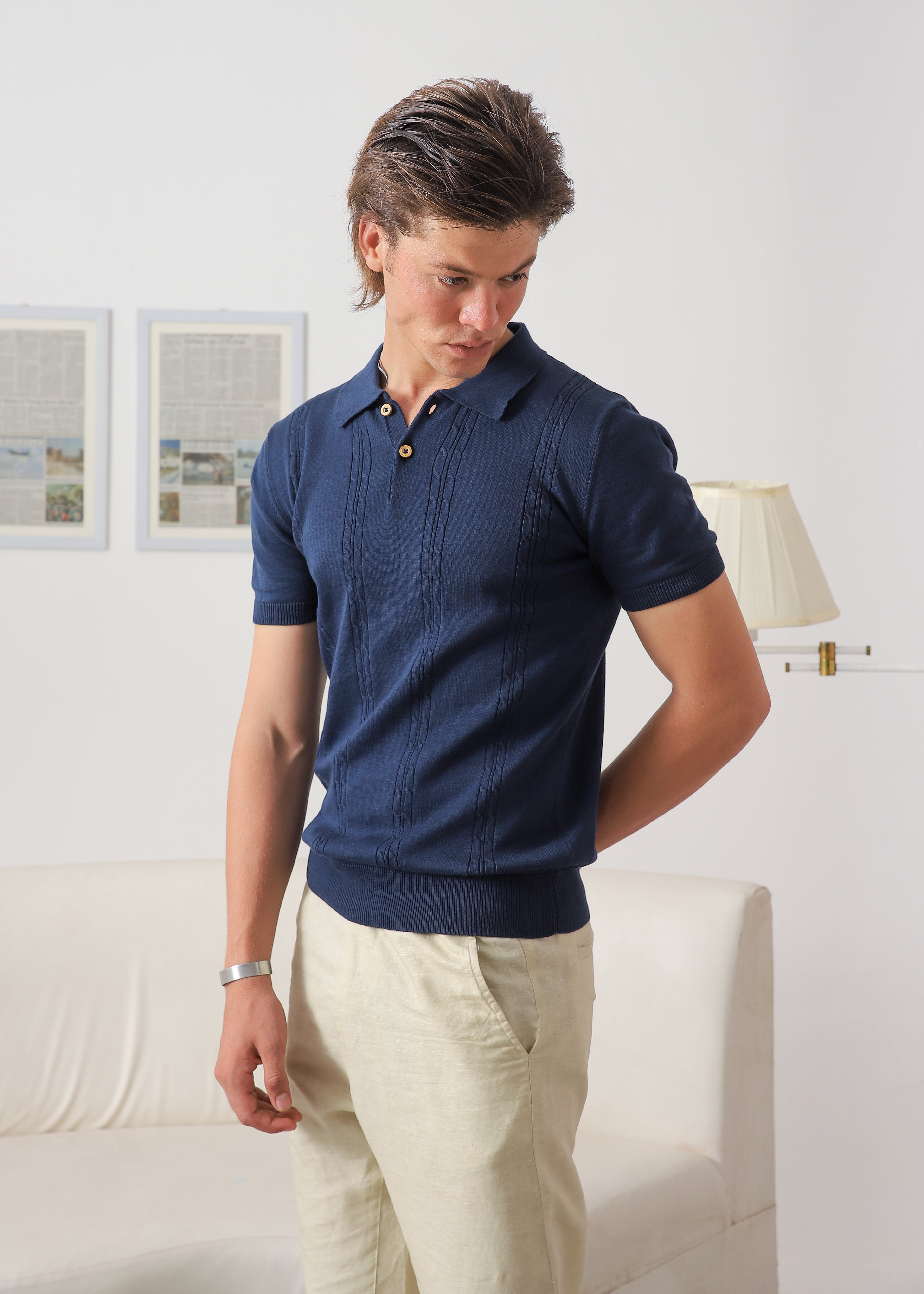 Three-quarter view of Wear Anarchy navy blue textured knit polo shirt for men with short sleeves and button placket