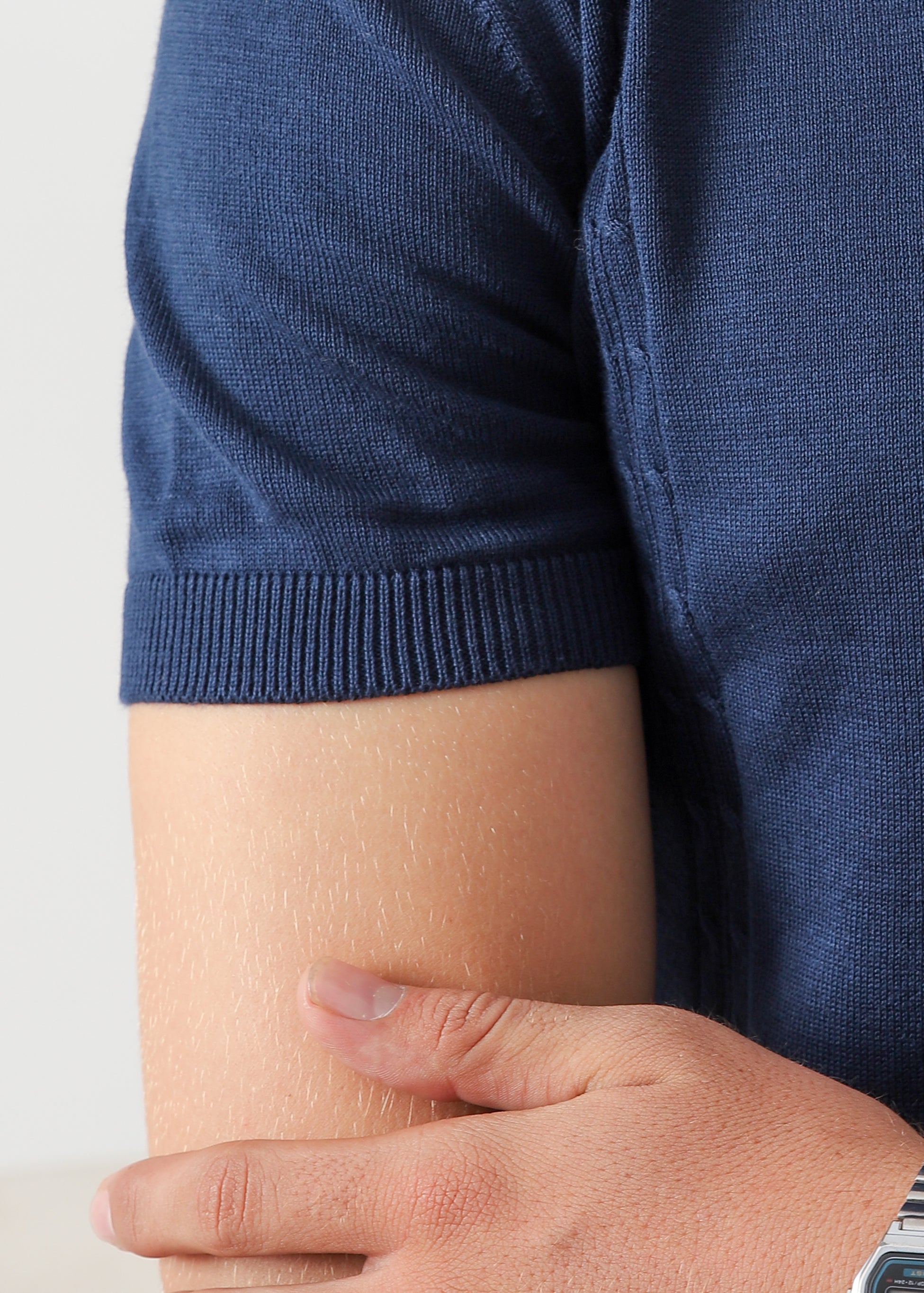 Close-up of Wear Anarchy navy blue textured knit polo shirt showing short sleeve ribbed cuff detail