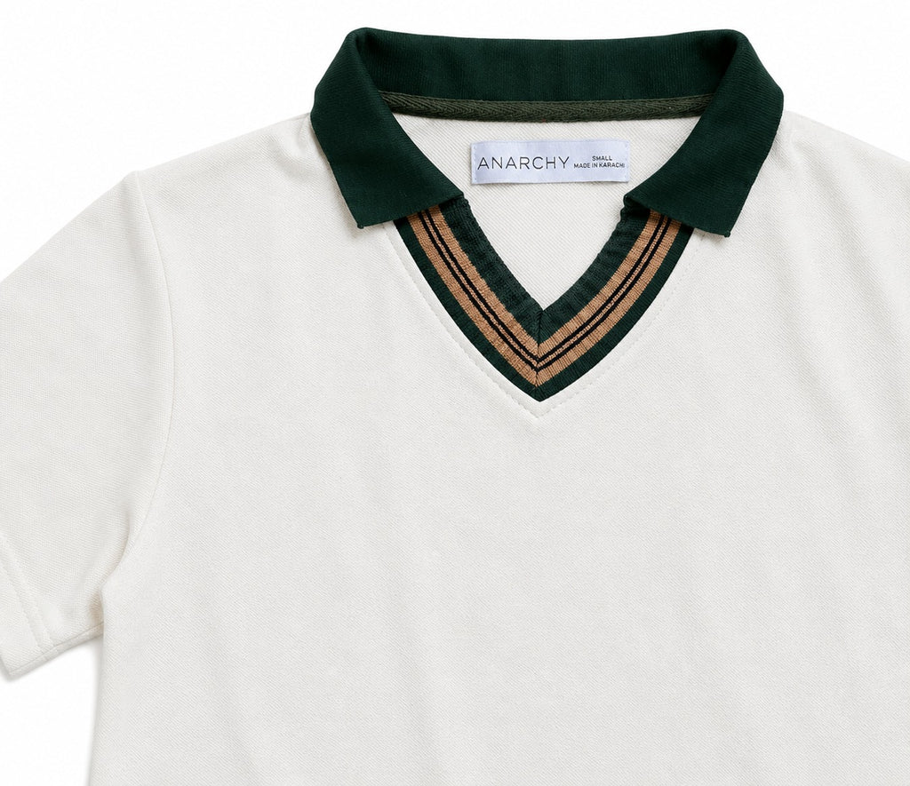 Close-up of Wear Anarchy off-white polo shirt with dark green collar and camel striped V-neck trim