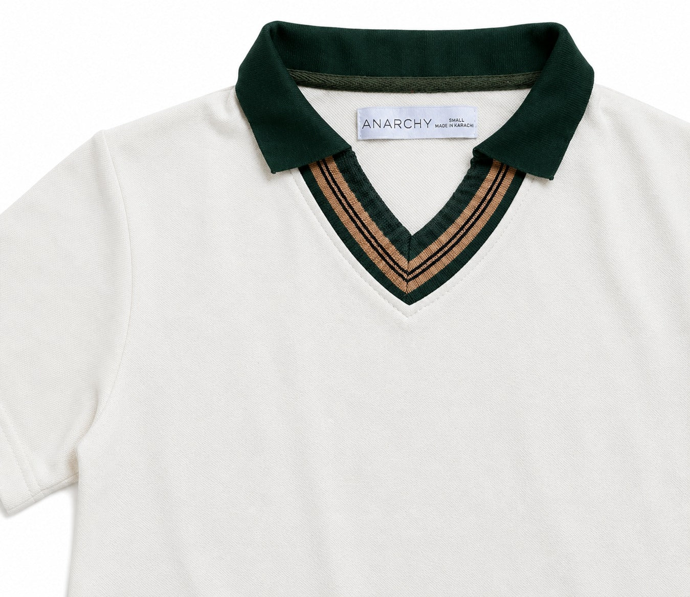Close-up of Wear Anarchy off-white polo shirt with dark green collar and camel striped V-neck trim