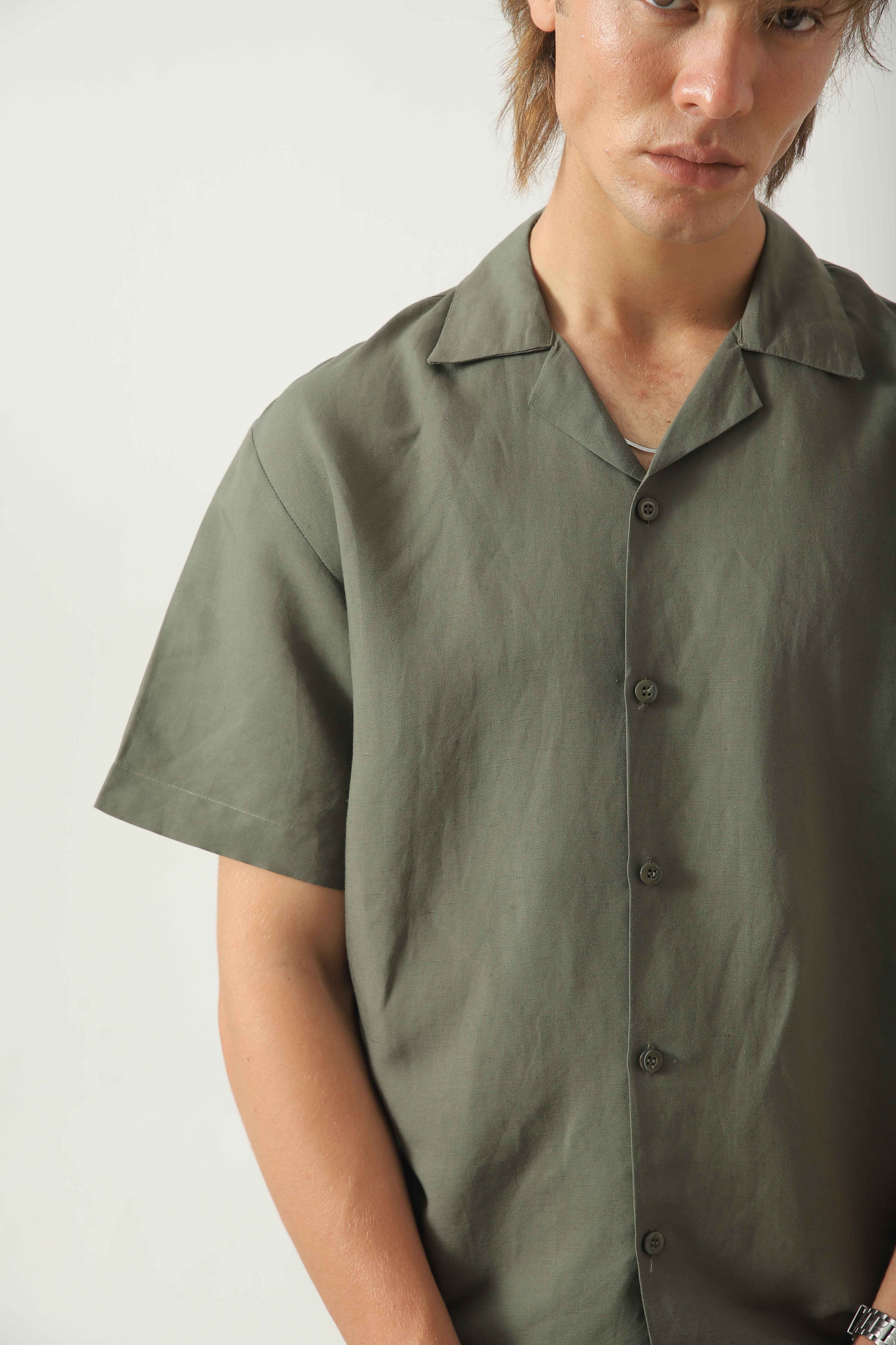 Close-up of Wear Anarchy olive linen resort shirt for men showing open camp collar, button front and textured linen fabric