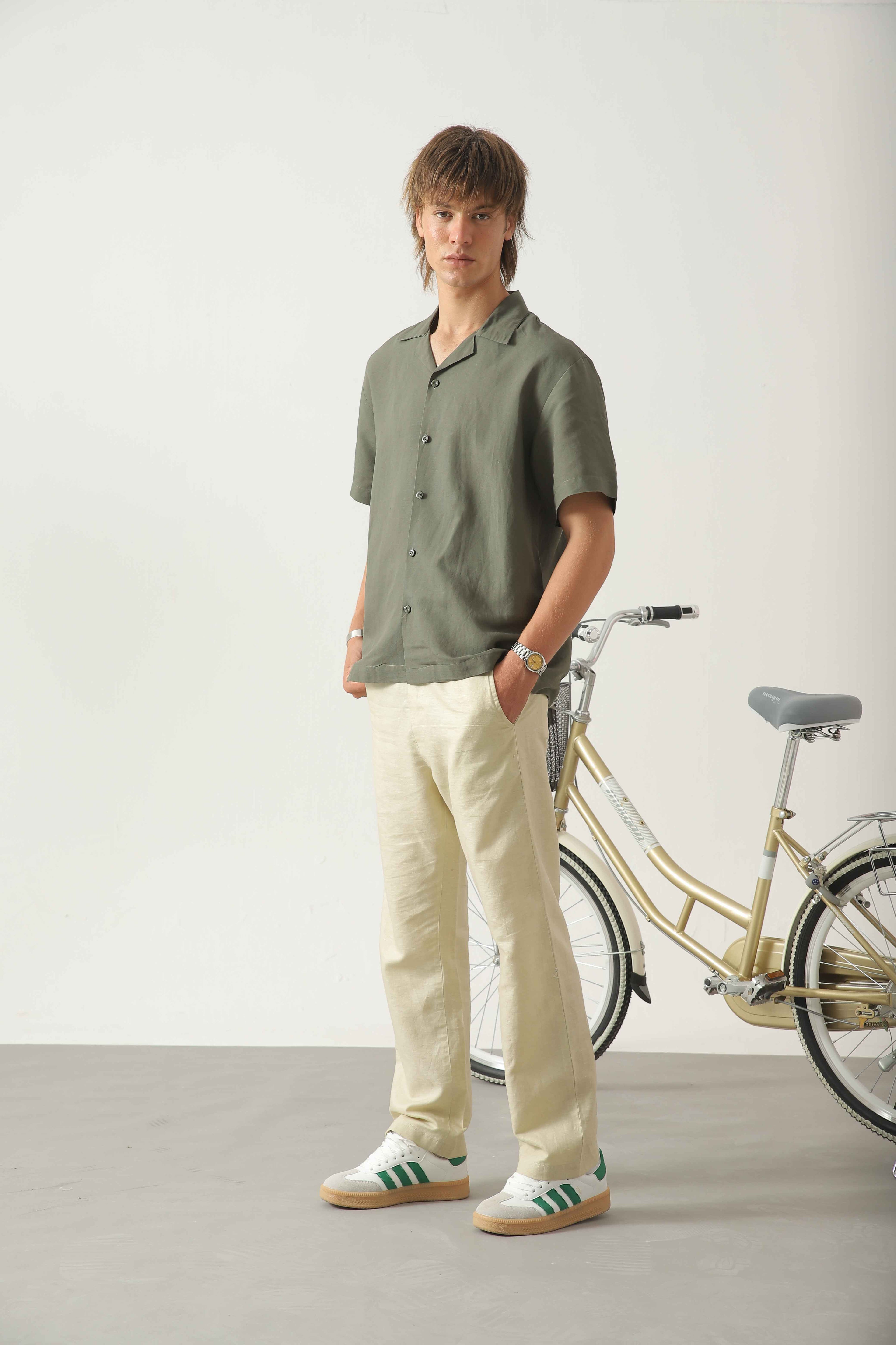 Wear Anarchy olive linen resort shirt for men styled with off-white trousers and casual sneakers