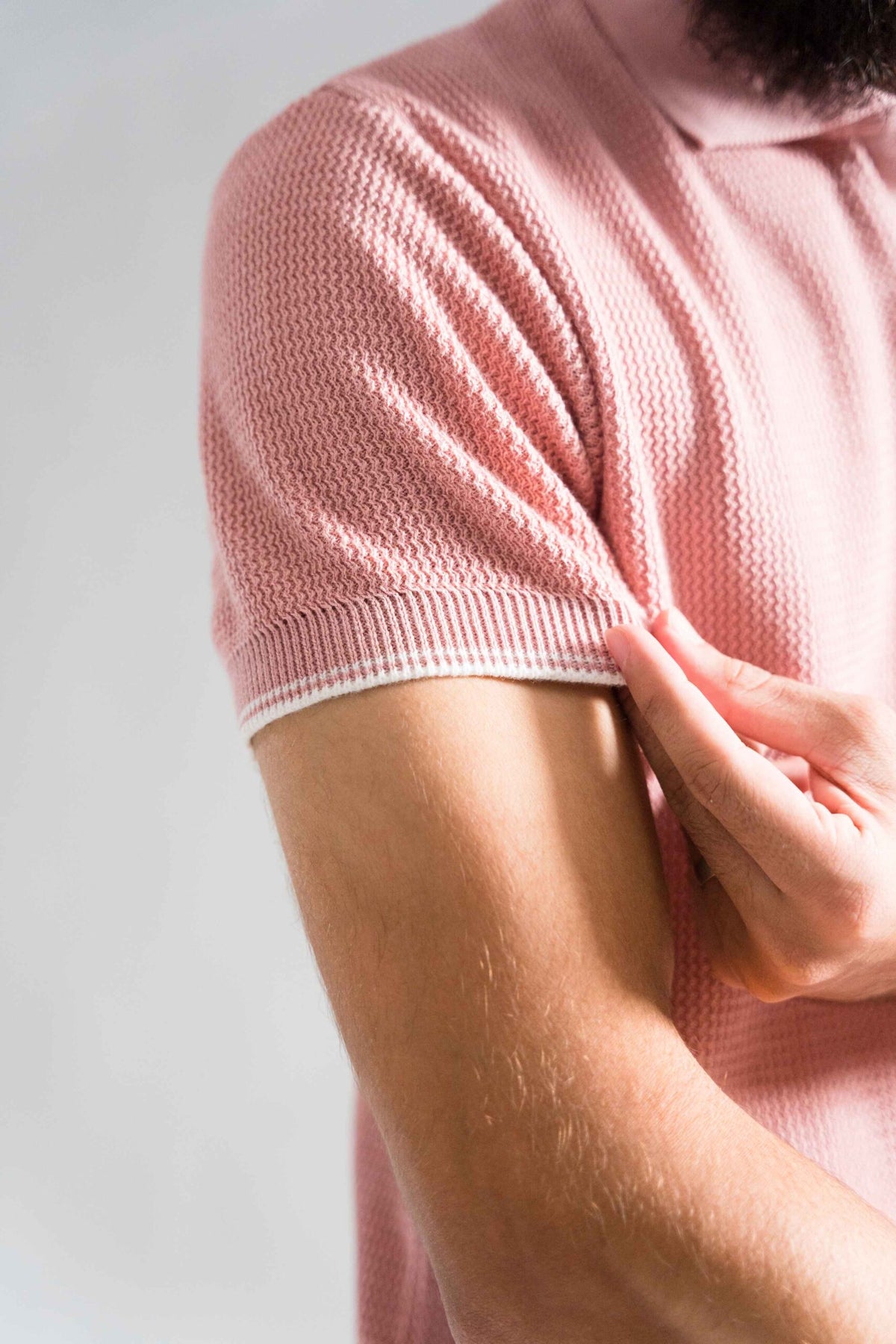 Close-up of Wear Anarchy Pink Knitted Polo showing textured short sleeve and contrast ribbed cuff detail