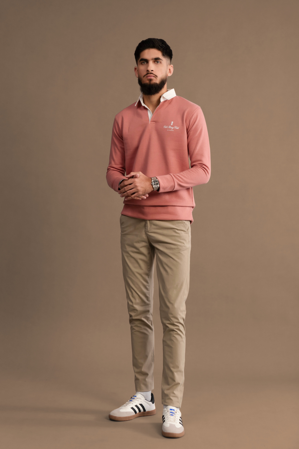 Wear Anarchy Pink Rugby Sweatshirt for men styled with beige trousers and white sneakers