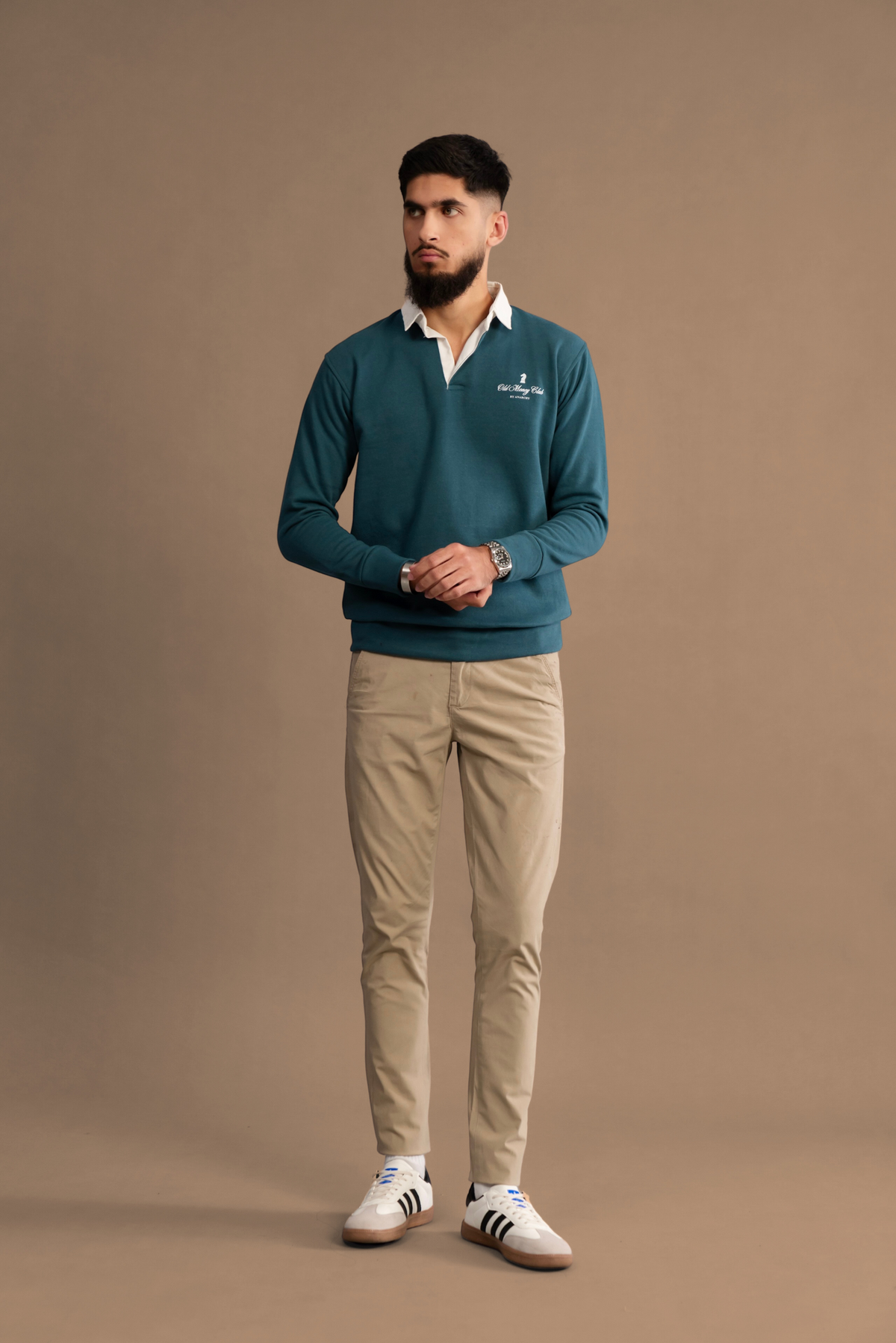Wear Anarchy Teal Rugby Sweatshirt for men styled with beige trousers and white sneakers