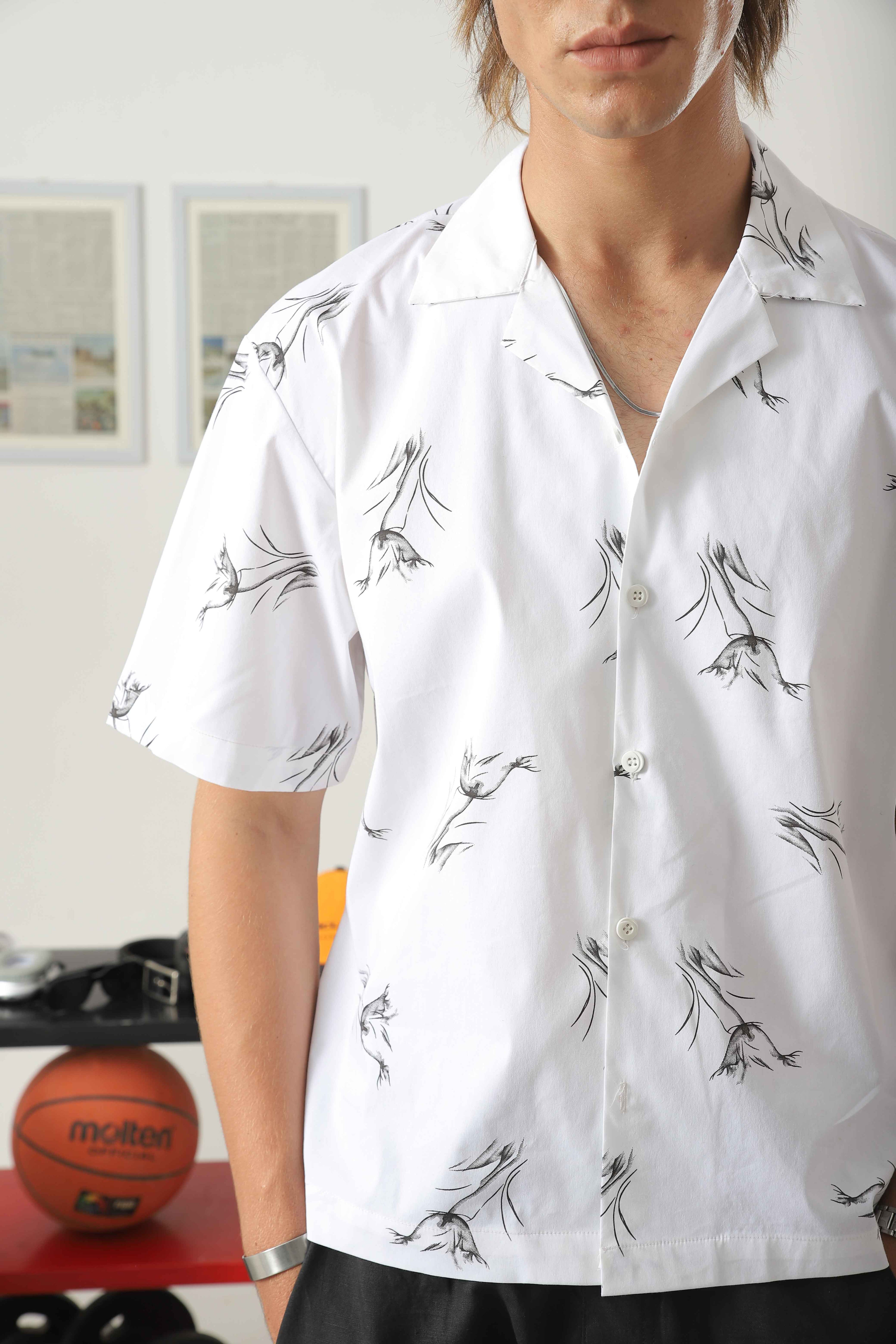 Close-up of Wear Anarchy white camp collar shirt for men with black botanical print and button-front design