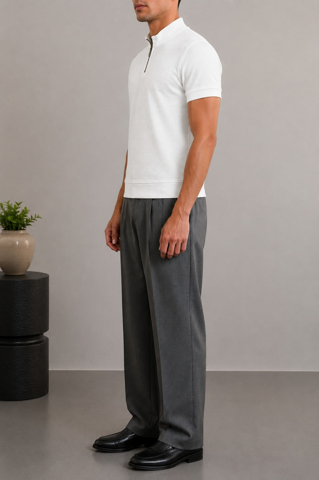 Side view of Wear Anarchy white textured quarter-zip polo shirt for men styled with grey trousers and black shoes