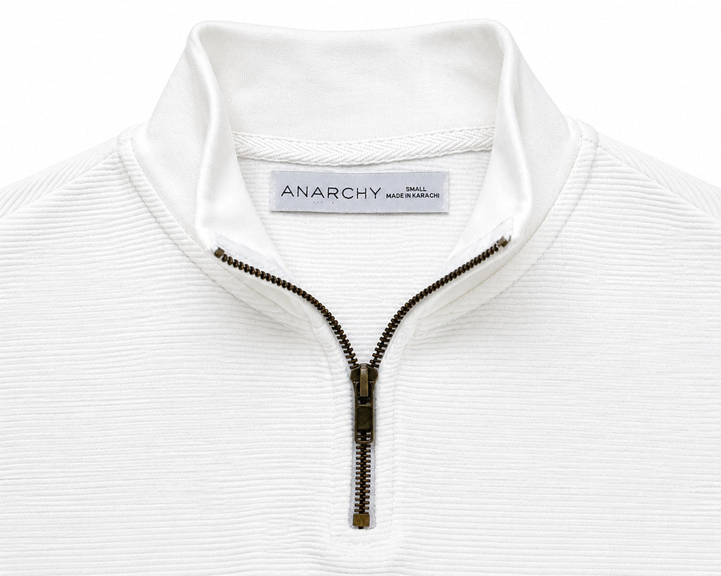 Close-up of Wear Anarchy white textured quarter-zip polo shirt showing mock neck collar and metal zipper detail