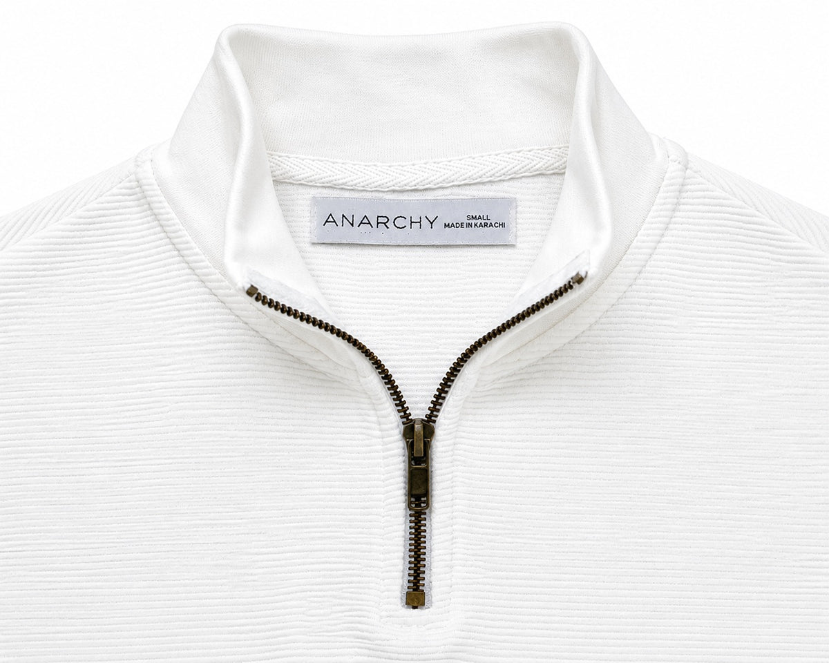 Close-up of Wear Anarchy white textured quarter-zip polo shirt showing mock neck collar and metal zipper detail